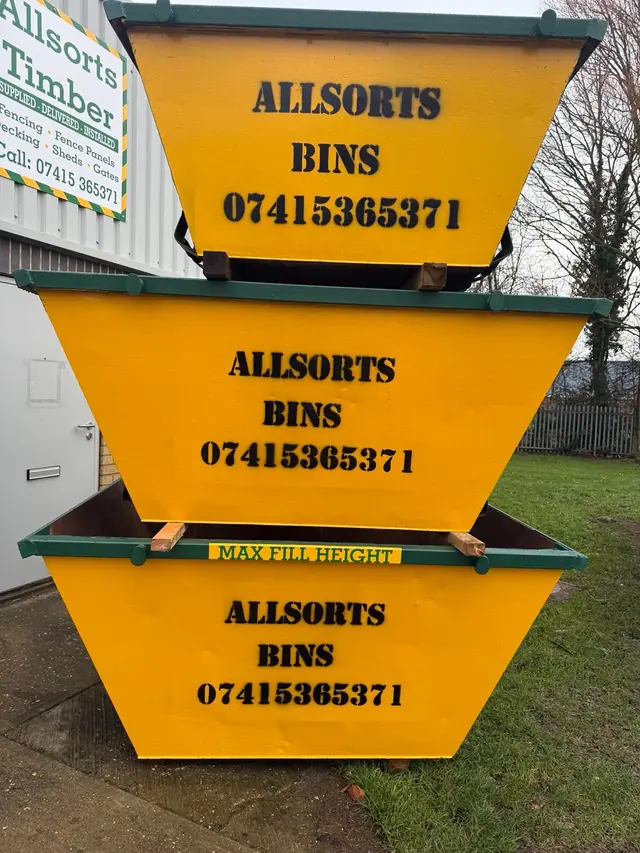 Stacked yellow Allsorts mini skips at the yard in Alford